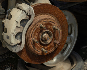 A rusty wheel hub on a wrecked truck chassis