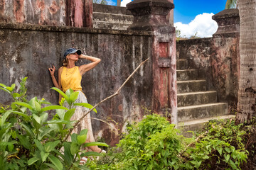 A woman posing near a wall of ancient ruins in Nha Trang, Vietnam - a moment of silence amidst the historical heritage and nature of Southeast Asia. Tourism concept
