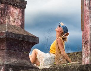 A woman sits on ancient ruins in Nha Trang, Vietnam - a moment of silence amidst the historical heritage and nature of Southeast Asia. Tourism concept