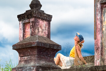 A woman sits on ancient ruins in Nha Trang, Vietnam - a moment of silence amidst the historical heritage and nature of Southeast Asia. Tourism concept