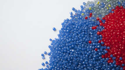 Assortment of Blue, Red, and Grey Plastic Granules on a White Background with Copy Space, Highlighting Recycling and Manufacturing Materials