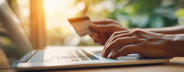 The hands making an online payment with a credit card and laptop.
