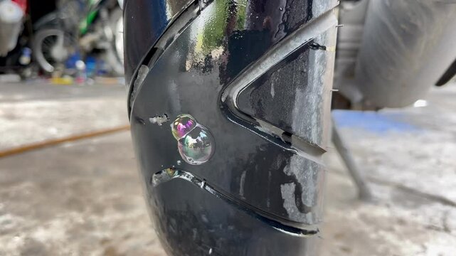 Checking motorcycle tires for holes with soapy water