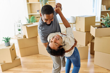 Portrait of a young couple unpacking, dancing, moving in and relocation to a new apartment, happy young couple family new beginning
