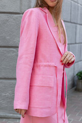 Closeup of unrecognizable woman in pink linen costume. Summer collection. Fashion model with red...