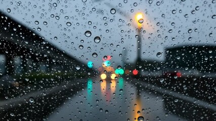 Rainy city street with blurred lights and raindrops on glass   - Powered by Adobe