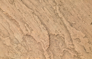 Natural sandstone texture with wavy, layered patterns. Earthy brown tones and organic lines ideal for backgrounds, nature designs, and geological themes