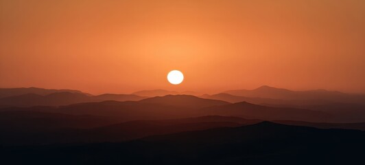 The breathtaking sunset over rolling mountains creating serene silhouettes.