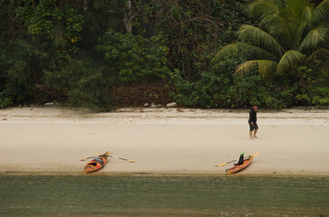 February 25, 2024, Lan Ha Bay: Kayaks and man on a beach. Cat Ba Archipelago. Vietnam.