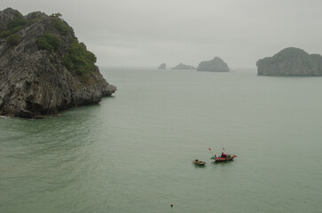Fishing boat and limestone cliffs. Lan Ha Bay. Cat Ba Archipelago. Vietnam.