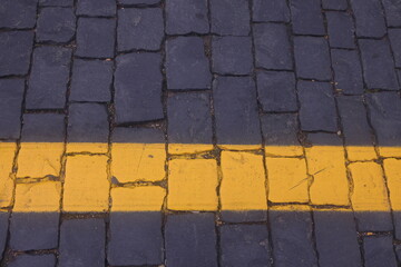 road markings on road paving stones, yellow paint on dark paving stones, 2