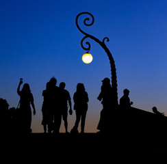 Black silhouettes of people on the horizon at sunset on a viewpoint