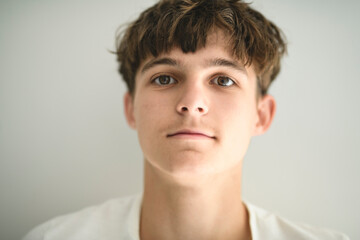 Fototapeta premium Portrait of teenage boy in casual t-shirt on light background in studio.