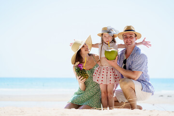 Happy caucasian family with father, mother, and daughter portrait on the beach.