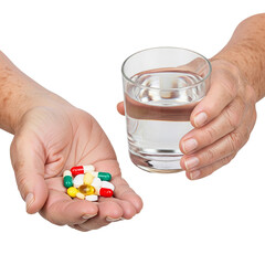 Two hands holding a variety of colorful pills and a glass of water. The background is transparent, emphasizing the objects in focus.