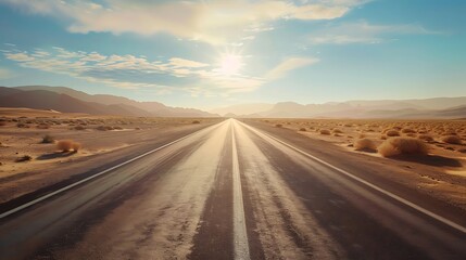 Fototapeta premium Empty asphalt road stretching into a desert landscape under a vibrant sky.