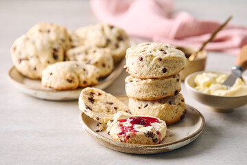 Scones with butter and cherry jam on ceramic plates