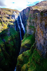 Majestic waterfall cascading down steep cliffs in the heart of Icelands stunning landscape
