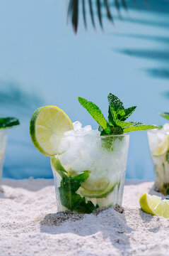 Refreshing mojito cocktail on sandy beach setting
