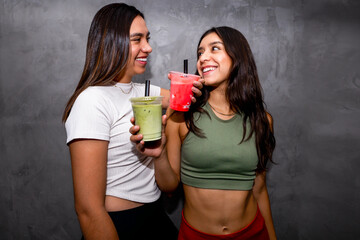 Two women enjoying healthy and refreshing fruit smoothies