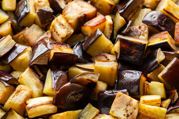 Sauteed aubergine chunks background texture. 