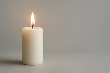 A single white candle burning against a plain light gray background