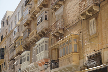 Charming Traditional Maltese Balconies on Residential Buildings in Valletta, Malta - Architectural Details and Sunny Facade in Mediterranean City