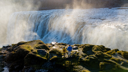 Majestic Dettifoss waterfall mesmerizes visitors in serene Icelandic landscape