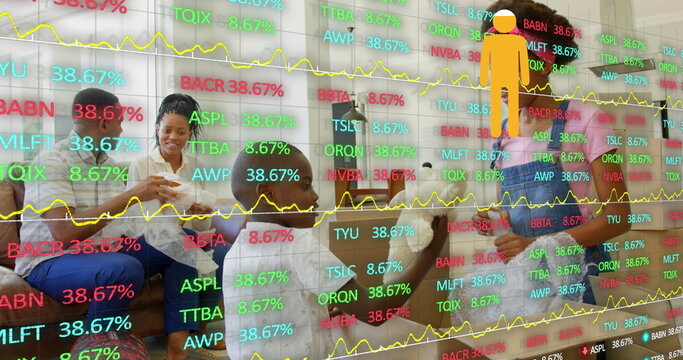 Holding wireless game controllers, family of four gaming on home sofa, with stock ticker overlay