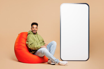 Full body young man wears green hoodie casual clothes big huge blank screen mobile cell phone...