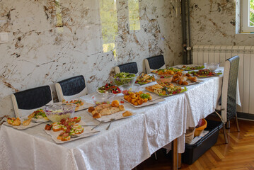 Food, salads, meat, barbecue, etc. are served on the tables, ready to eat.