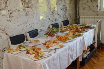 Food, salads, meat, barbecue, etc. are served on the tables, ready to eat.