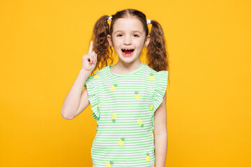 Little toothy cheery cute kid child girl 8-9 years old wears green t-shirt holding index finger up...