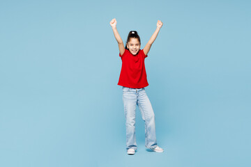 Naklejka na ściany i meble Full body little kid girl 8-9 years old wear red t-shirt have fun do winner gesture celebrate clench fist isolated on blue background child studio portrait. Mother's Day love family lifestyle concept