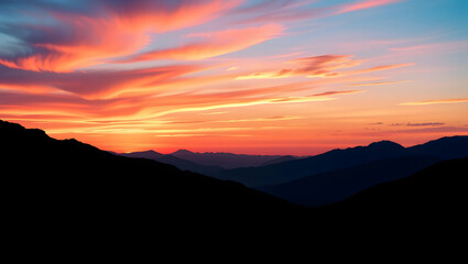 Fototapeta premium Dramatic sunset over mountain peaks with vibrant orange and pink colored sky