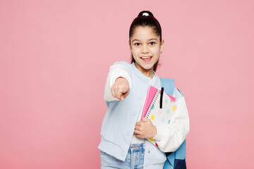 Young happy school girl 8-9 year old wear blue casual clothes backpack point index finger camera on...