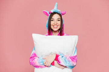 Young smiling happy cheerful fun cool woman wearing domestic costume with hoody hold pillow lying...
