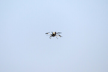 Drone is flying on isolated blue sky