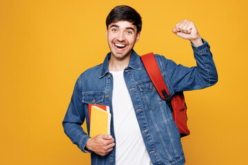 Young boy student wear jeans casual clothes backpack bag hold books doing winner gesture celebrate...