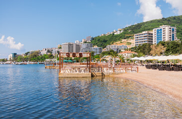 Summer beachfront with modern resort buildings and calm sea. Coastal lifestyle, leisure tourism,...