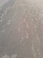 Flip-Flop Footprints on Wet Sand at Karon Beach, Phuket, Thailand