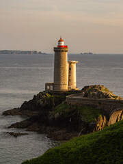 Petit Minou Lighthouse in Finistère at sunset with rocky coastline and golden light
