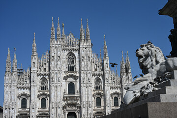 Milan, Italy - Duomo cathedral and the lion sculpture on the base of the monument dedicated to Vittorio Emanuele II