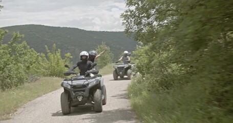 Friends enjoy a scenic ATV ride through the mountains. They wave and cheer as they navigate the winding dirt road, showcasing a sense of adventure and freedom. - Powered by Adobe