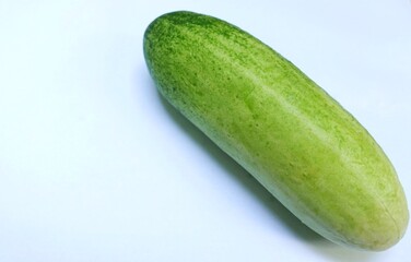 A fresh and clean cucumber isolated on a bright background.