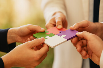 Business concept of teamwork and collaboration with hands joining colorful puzzle parts together. 