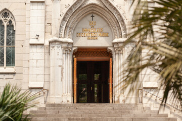 Fototapeta premium Historic entrance of a college building featuring ornate architecture and religious symbols in the afternoon light