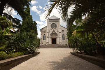 Fototapeta premium Stunning view of a historic church with lush greenery on a sunny day in the city