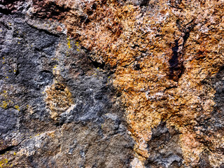 Close-up of natural stone surface with colorful textured mineral layers.