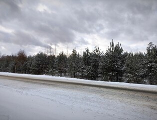 Winter landscape. snow-covered pine trees along the highway. Winter road with snow